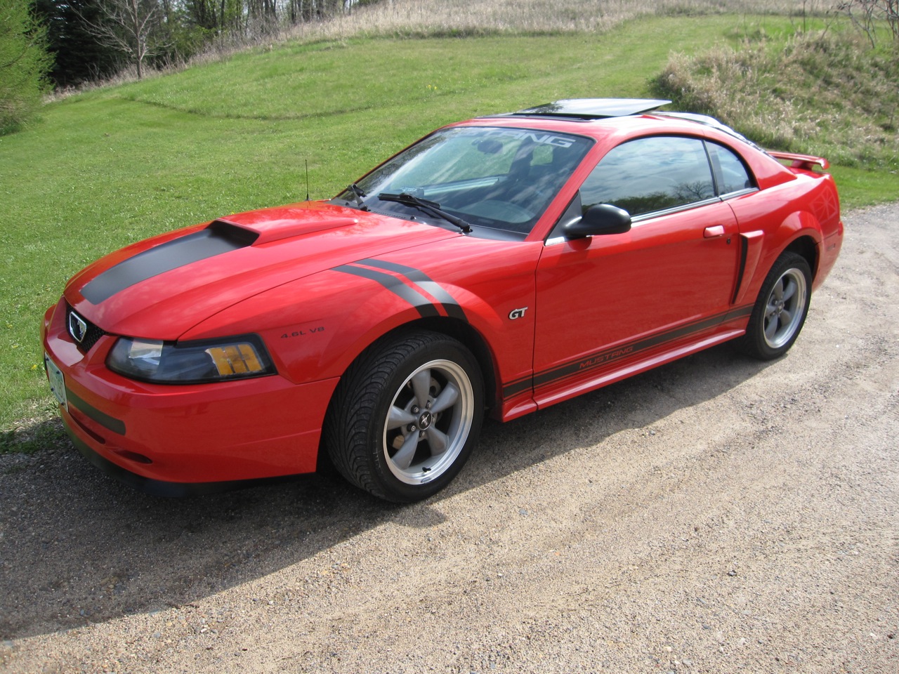 Front three-quarter view of my Torch Red Mustang GT with black hood and side graphics